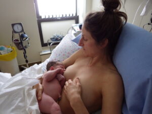 Veronique Rioux laying in bed while breastfeeding her newborn baby 