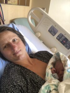 Veronique Rioux lying down in hospital bed while holding her new born baby