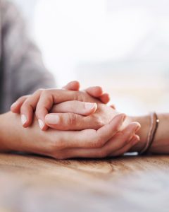 picture of a hand being held and cup in between other hands