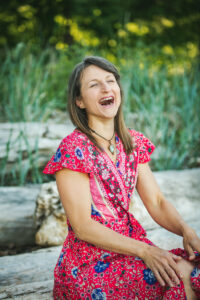 Veronique Rioux sitting in a colourful dress laughing