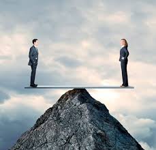 a women and a men on balance board balancing on tip of a mountain