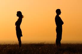 a men and a women back to back with their arms cross in orange sunset glow
