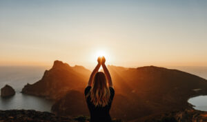 a person with long hair holding their hands above their head and look like they are holding the sun in their hands