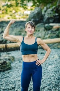 Veronique Rioux flexing one of her biceps in a tank top and legging