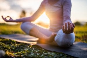picture of a person sitting cross legs with their hands in mudras, we don't see person head